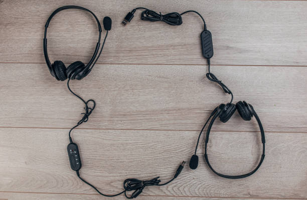 istock Two black headsets on wooden background 1300328698