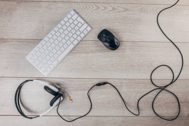 istock Wireless keyboard, computer mouse and headset on wooden background 1300330261