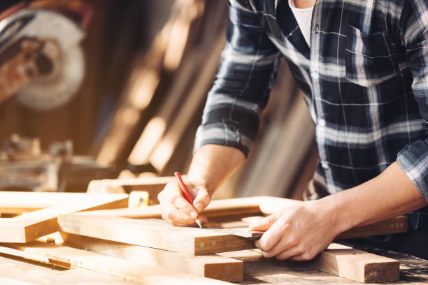 istock A young male carpenter builder working overall equals a wooden bar with a milling machine in the workshop, in the background wooden 1300331876