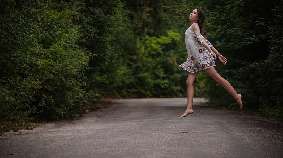 women is hailing a car on a road. Thumbing a ride. Outdoors vacation. Asian