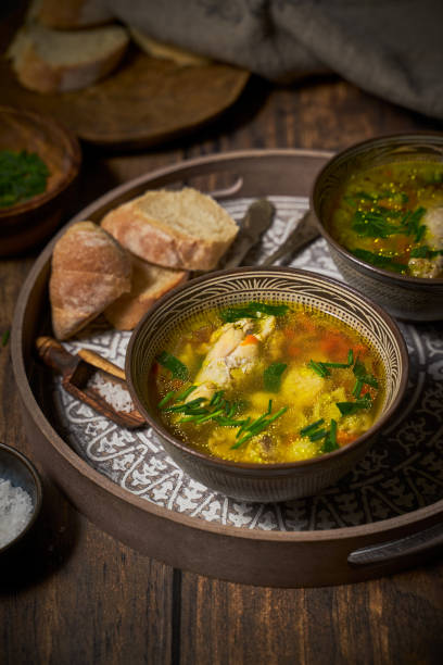 istock Chicken soup in clay bowls, bread on rustic background 1300333163