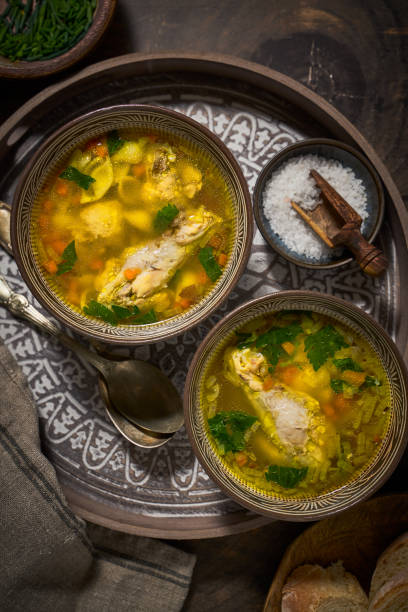 istock Asian style chicken soup in two clay bowls, top view 1300333176