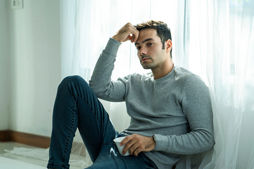 Working men are under stress from working at home during the virus outbreak. Young businessman working from home. The young man was sitting and physically from a lock down due to viral conditions.