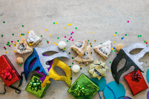 istock Purim celebration concept (jewish carnival holiday) on white background, top view, copy space. flat lay with hamantaschen cookies and purim mask. 1300333539