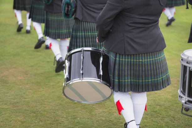 Detail of a Scottish kilt and marching pipe band from waist down.