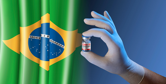 Hand holding vial ampoule vaccine for Corona Virus Covid-19 with brazilian Flag