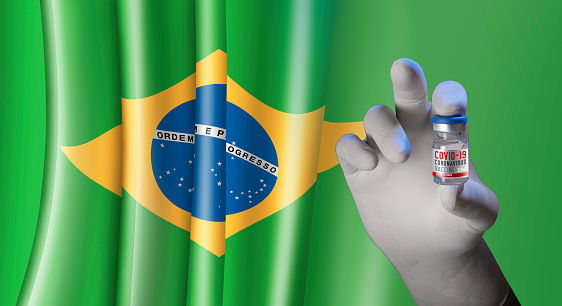 Hand holding vial ampoule vaccine for Corona Virus Covid-19 with brazilian Flag