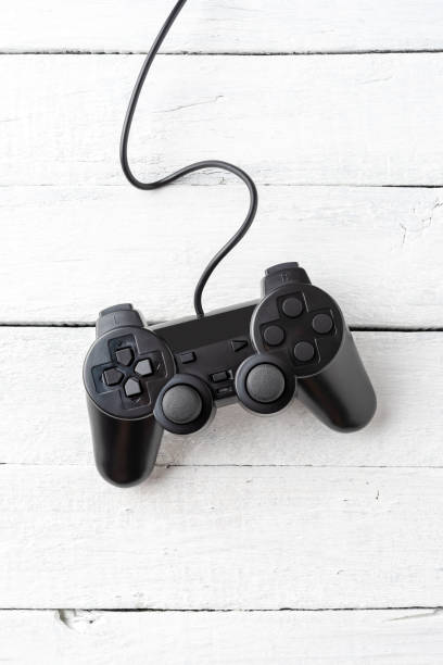istock Overhead shot of video game console on white wooden background. Computer player concept. Close up 1300336811