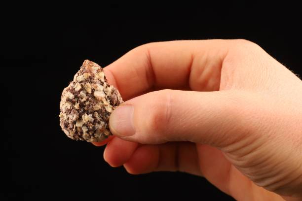 istock Chocolate candy sprinkled with waffle crumbs in hand 1300337649
