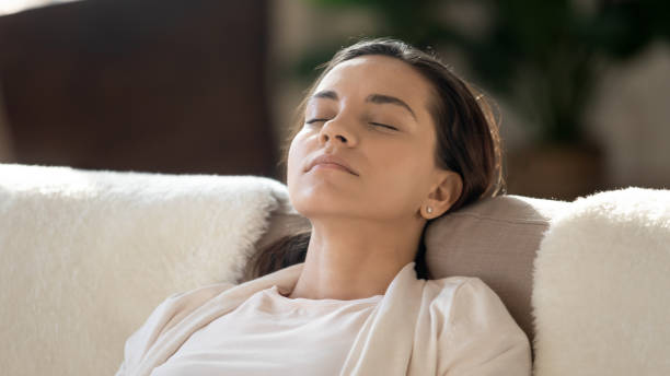 istock Tired young lady resting on couch napping after work day 1300340791