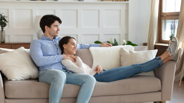 istock Loving young newlyweds embracing on sofa imagining happy future together 1300340844