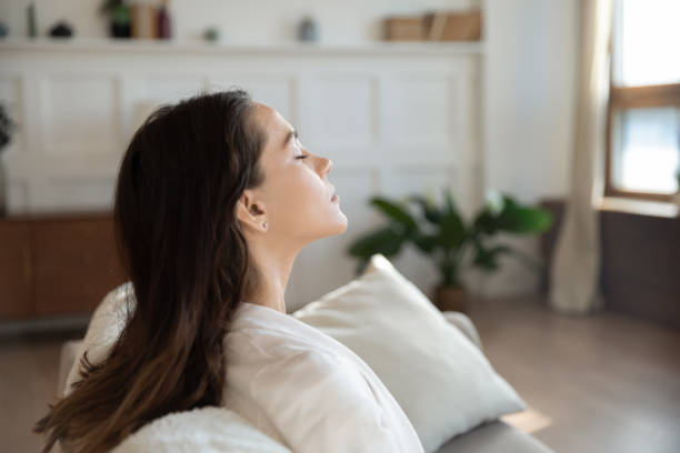 istock Serene lady taking pause meditating on sofa with closed eyes 1300340874