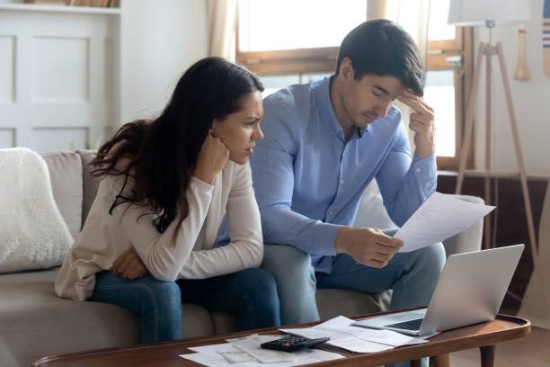 istock Concerned young married couple studying bank letters informing about debt 1300340919