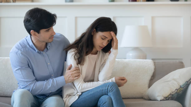 istock Caring young man hugging suffering woman shoulders supporting in grief 1300340955
