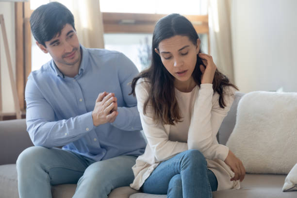 esposo de la joven que apretando las manos pidiendo perdón después de la pelea - pleading men women forgiveness fotografías e imágenes de stock