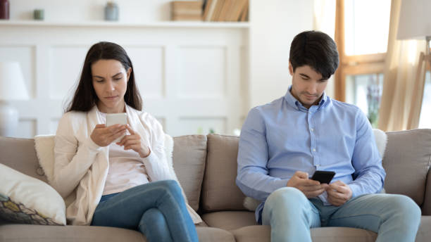 istock Focused young male and female spending time online using smartphones 1300340965
