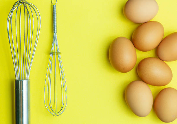 istock Chicken eggs, brown eggs, broken egg in carton box on yellow background. Top view natural eggs in carton box product concept 1300341927