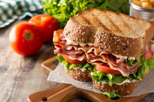 BLT sandwich and fries BLT sandwich and fries on wooden table sandwich stock pictures, royalty-free photos & images