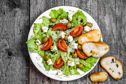 Vegetarian salad, vegetable greek salads, top view on rustic table