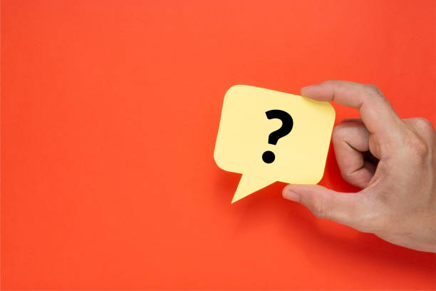 A man holding speech bubble with a question mark. Creative concept on red background. A man holding speech bubble with a question mark. Creative concept on red background. question mark stock pictures, royalty-free photos & images