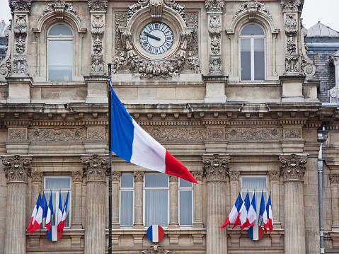 Clusters of the French national flag adorn a government building in Lille in advance of a Bastille Day parade