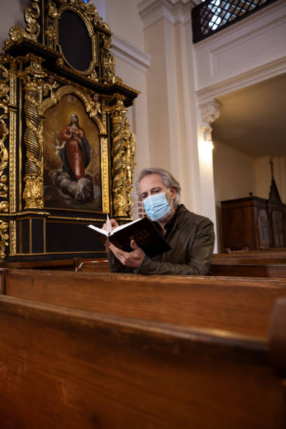 istock Praying in church wearing mask 1300346331