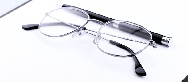 istock Glasses and pen on clipboard on blue background, wide angle view. 1300346784