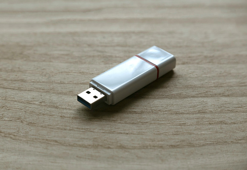 Selective focus of usb flash drive isolated on a wooden background.