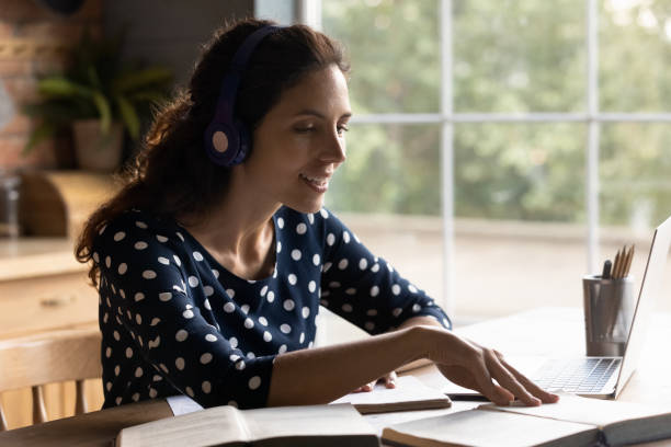 istock Young woman in headphones study online on computer 1300347600