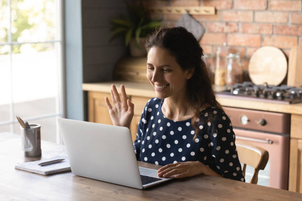 istock Smiling young woman talk on video call on computer 1300347605