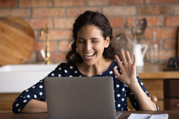 istock Smiling young woman talk on video call on laptop 1300347613