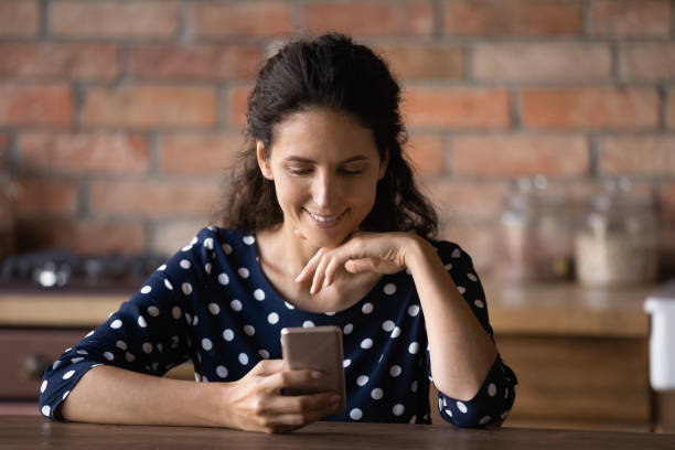istock Happy young woman use cellphone texting online 1300347628