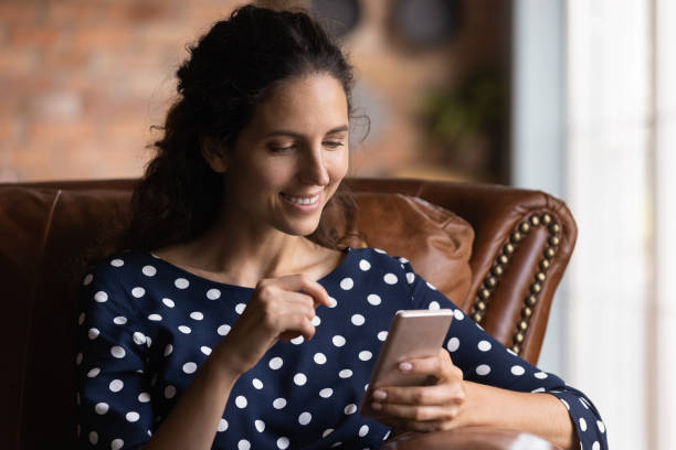 istock Smiling woman use smartphone talking on video call 1300347637