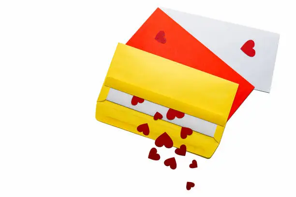 Red little hearts coming out from yellow envelope on white background with copy space, loveletter concept, close-up