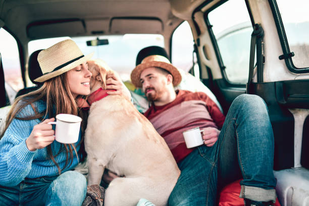 istock Smiling Couple Enjoying Tea While Resting With Dog In Van Back 1300348489