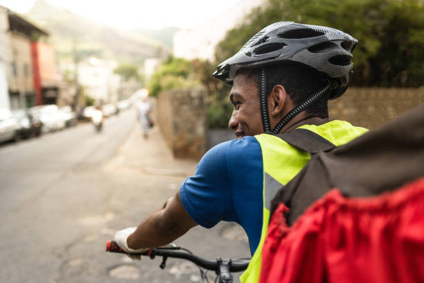 vista trasera de un repartidor feliz en la calle - brazil bicycle rio de janeiro outdoors fotografías e imágenes de stock