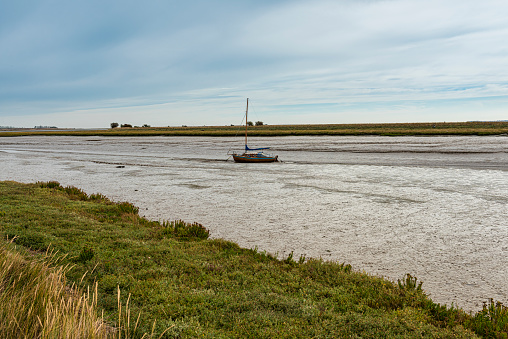Boat on the Swale Estuary at low tide at Oare near Faversham in Kent, overlooking the isle of Sheppey