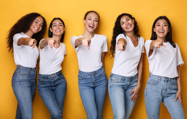 istock Cheerful Multiethnic Ladies Pointing Finger At Camera Posing, Yellow Background 1300351697