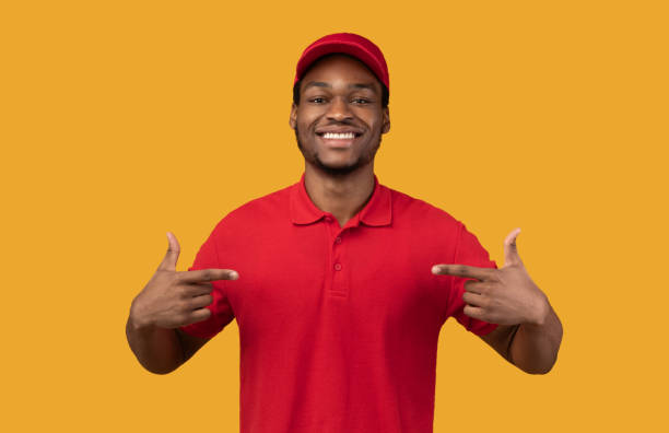 istock Smiling black bearded delivery man pointing at himself 1300352392