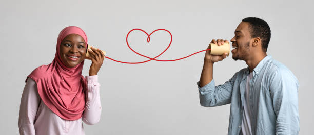 istock Young black muslim couple with can phone on grey background 1300352665