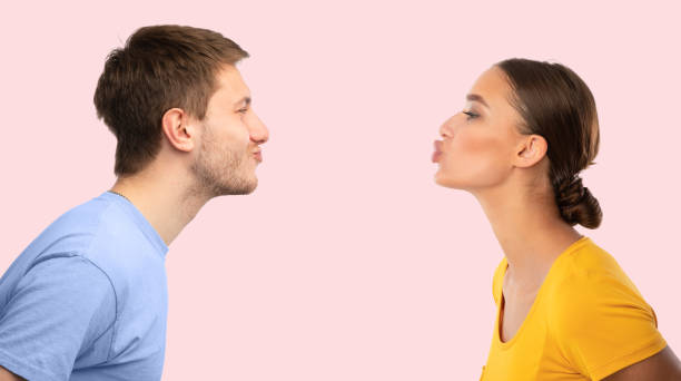 hombre y mujer llegando el uno al otro tratando de besar - kissing blowing a kiss blowing women fotografías e imágenes de stock