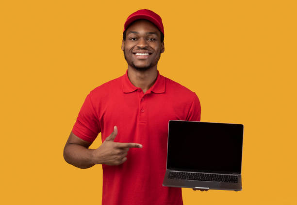 istock Black delivery man holding laptop with blank screen for mockup 1300352918