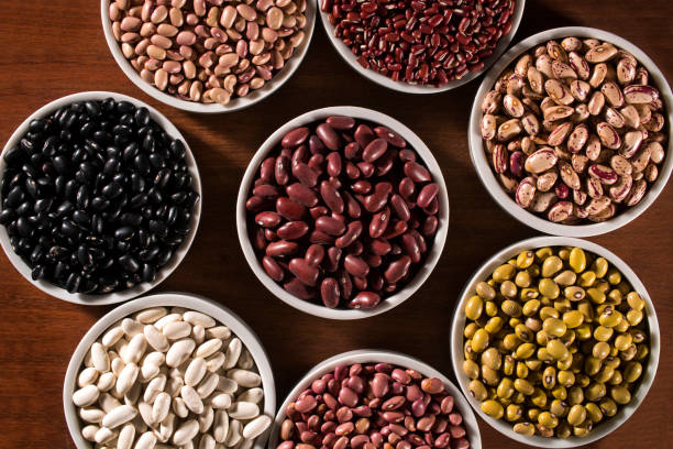 istock Assorted beans in bowls on wood background 1300354585