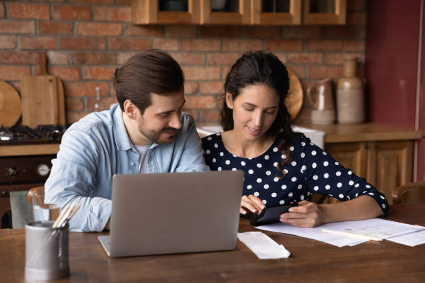 istock Young couple calculate expenses paying bills on laptop 1300355155