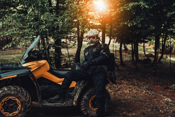 istock Man sitting on quad in forest and preparing for ride 1300355391