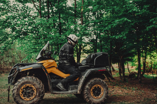 istock Man sitting on quad in forest and preparing for ride 1300355394