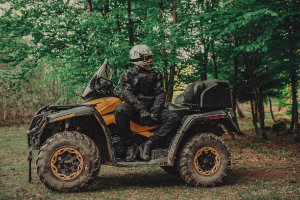 istock Man sitting on quad in forest and preparing for ride 1300355407