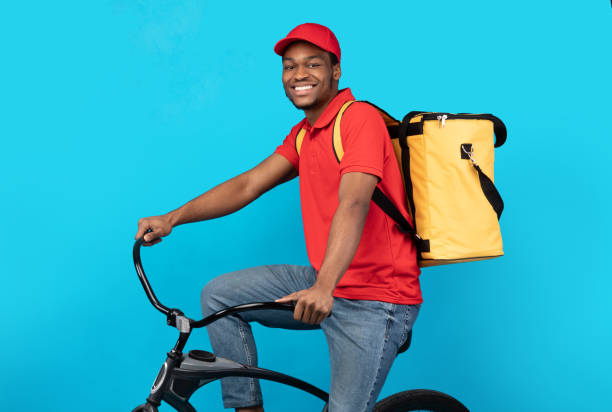 livreur de livraison de sourire conduisant le vélo au studio - refrigeration cycle photos et images de collection