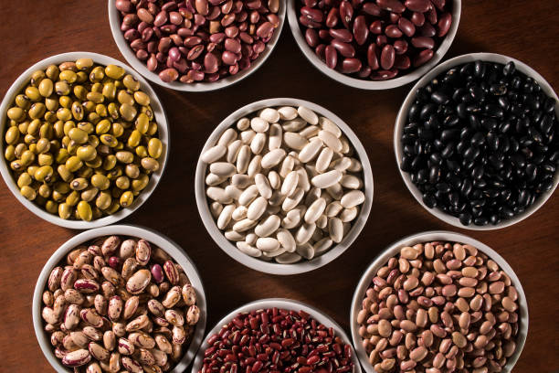 istock Assorted beans in bowls on wood background 1300356555