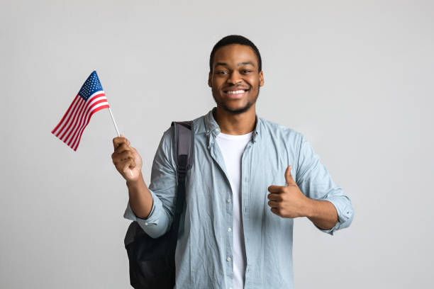 istock Happy black man showing thumb up and american flag 1300356793